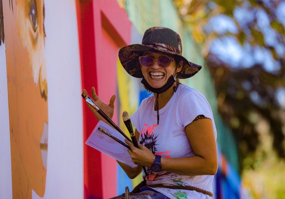 The artist, Kilia Llano, at work on the Santo Domingo mural.