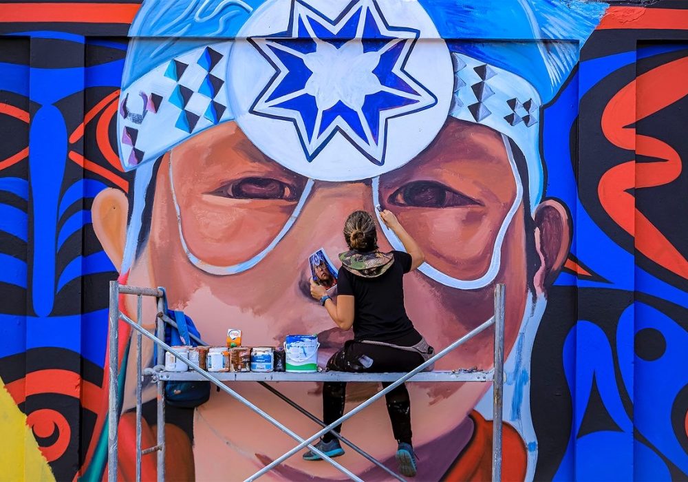 The artist, Kilia Llano, at work on the Santo Domingo mural.
